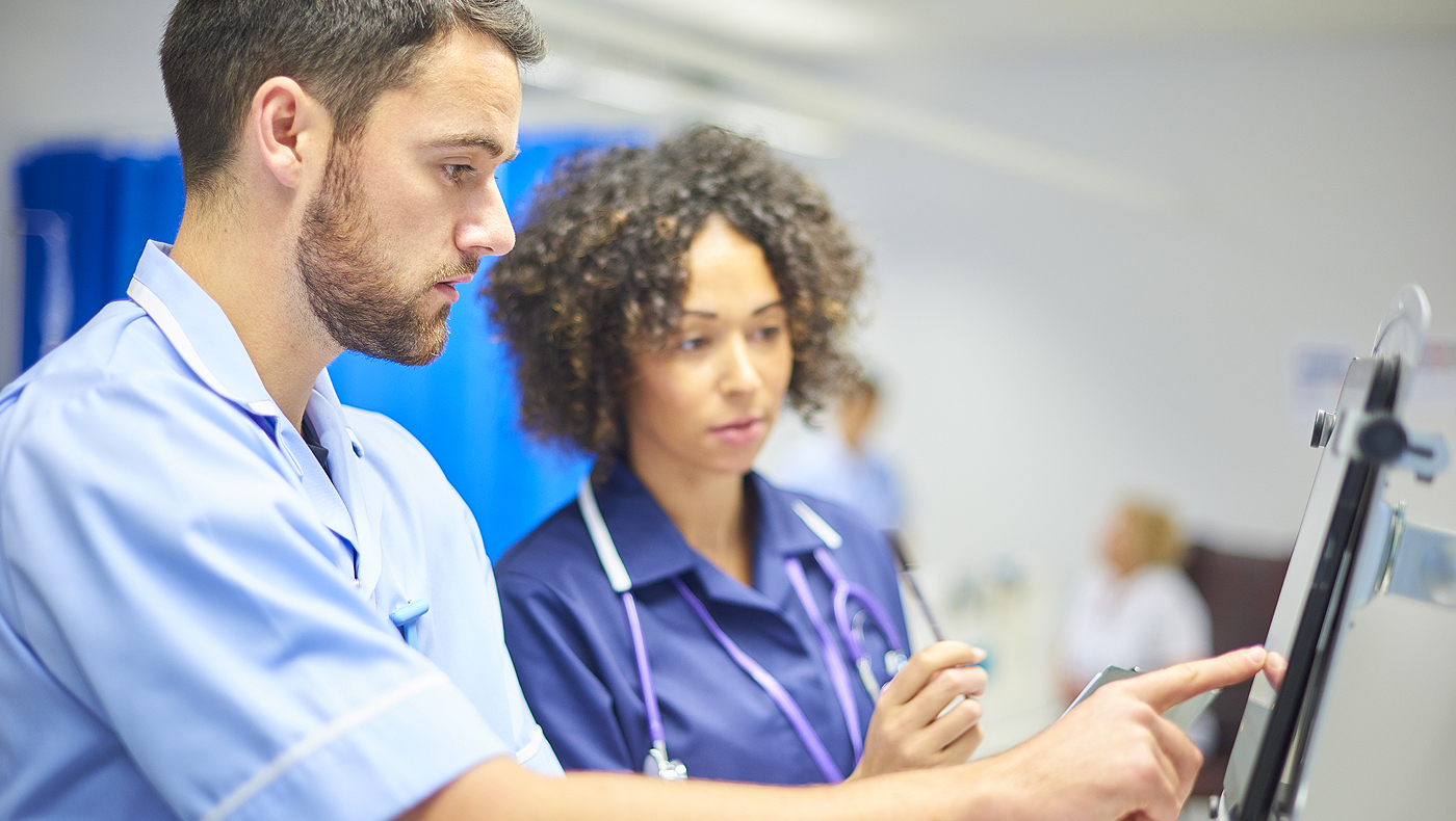 male and female medical professionals looking at computer monitor