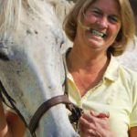 Pat Aulgur, RN posing with white horse