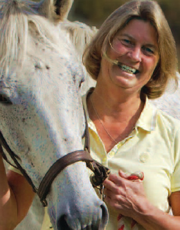 Pat Aulgur, RN posing with white horse