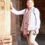 Karen Gates, RN Refresher online program graduate leaning on ornately decorated stone columns.