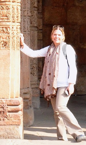 Karen Gates, RN Refresher online program graduate leaning on ornately decorated stone columns.