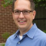 Mark Okonowicz, Project Management Certificate program graduate standing for a head shot outdoors.