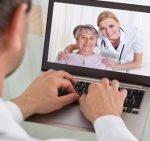 medical professional typing on laptop and viewing patients