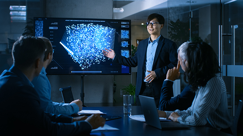 Standing man pointing at screen with big data in meeting