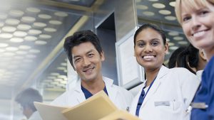 three medical professionals looking at a report