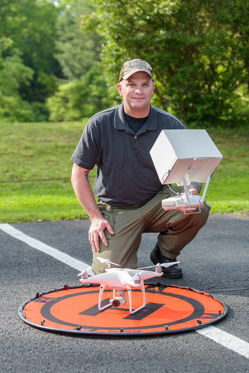 Tavis Miller kneeling over a target with a drone in the center