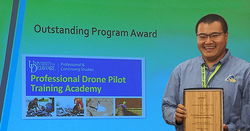 Vic Wang poses with 2019 UPCEA Mid-Atlantic Region Outstanding Program Award plaque for the UD PCS Professional Drone Pilot Training Academy