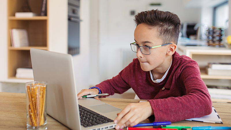 Boy taking an online reading skills class at home