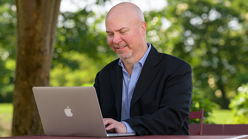 Tom Nesterak working outside on a laptop