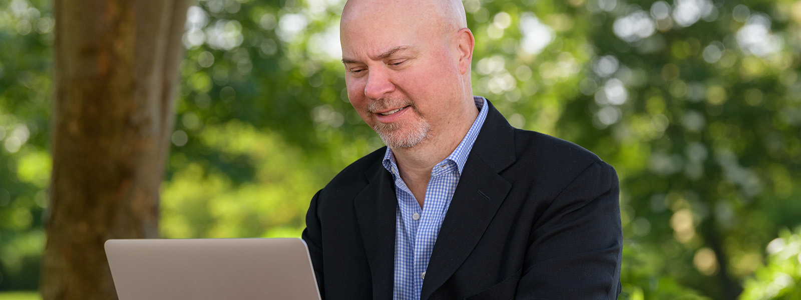 Tom Nesterak on laptop outdoors