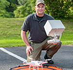 Tom Nesterak on laptop outdoors