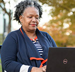 Thonnia Lee on laptop outdoors