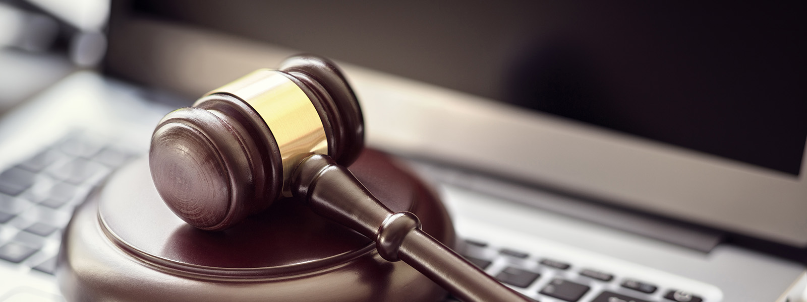 lawyer gavel on top of laptop keyboard