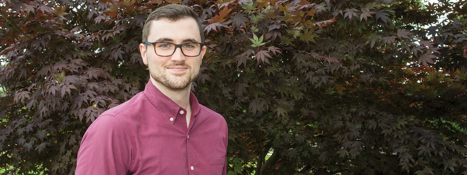 Paralegal student William Simons standing outside in front of trees