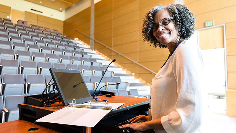 Smiling female professor in empty lecture hall