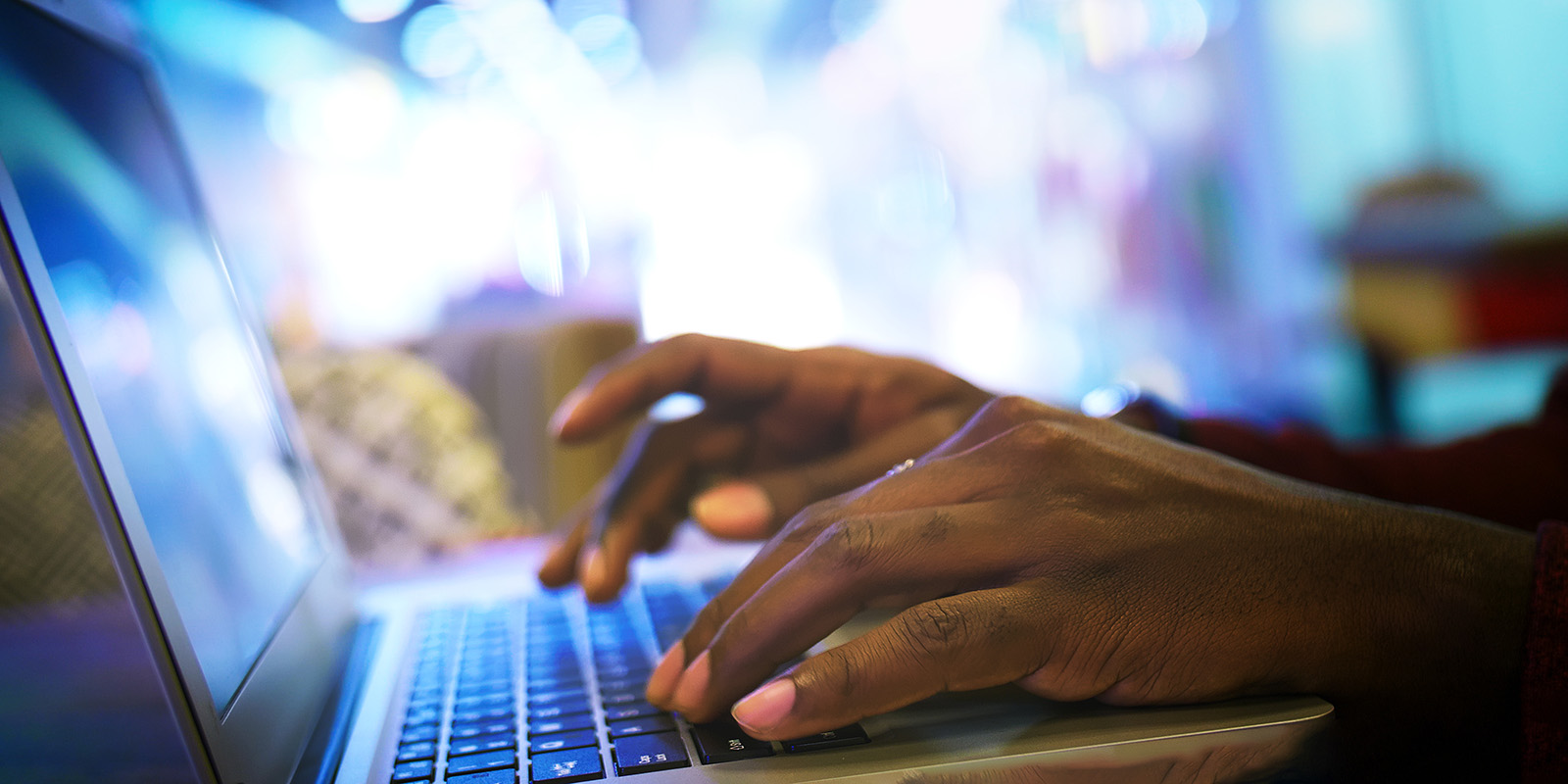 Hands type on laptop keyboard