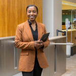 Joy Dufitumukiza standing in front of UD Morris Library turnstiles.