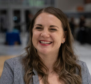 A smiling woman talks about her experiences in the course.
