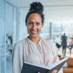 Woman in lab holding lab notebook