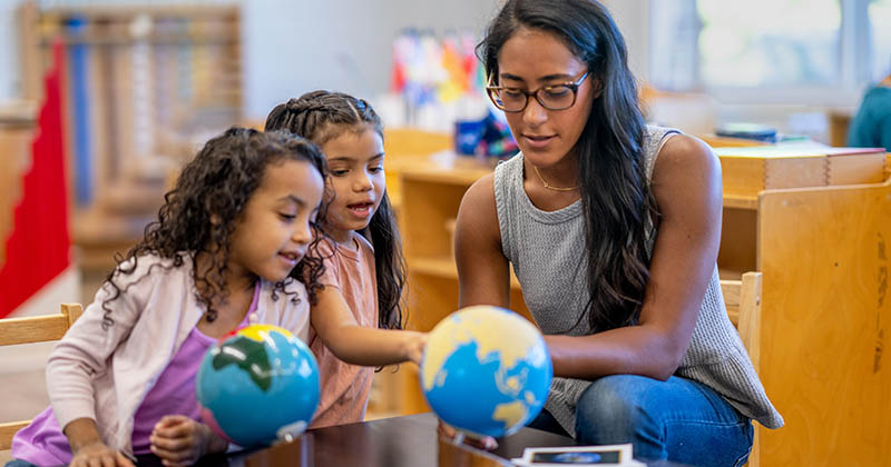 Children and educator engaged in hands-on learning in a Montessori primary classroom.